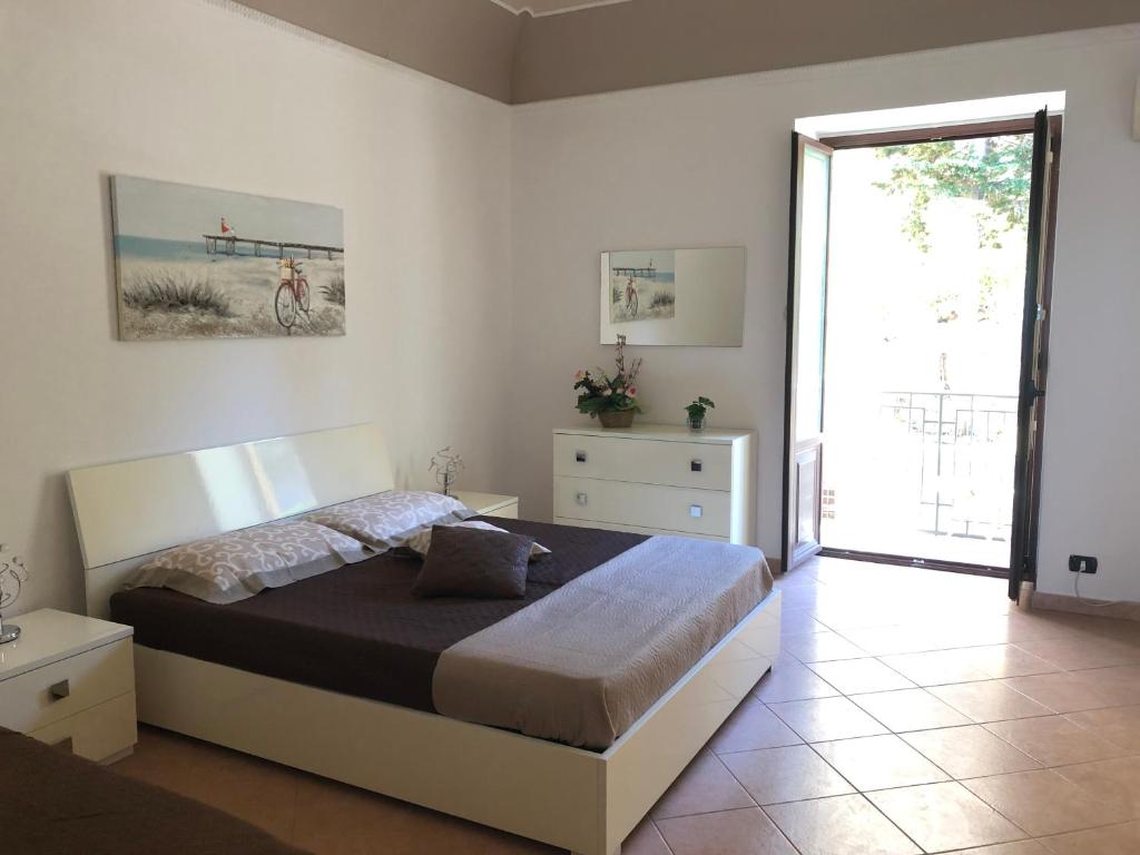 a bedroom with a bed and a large window at La Casa Sulla Scogliera in Cefalù