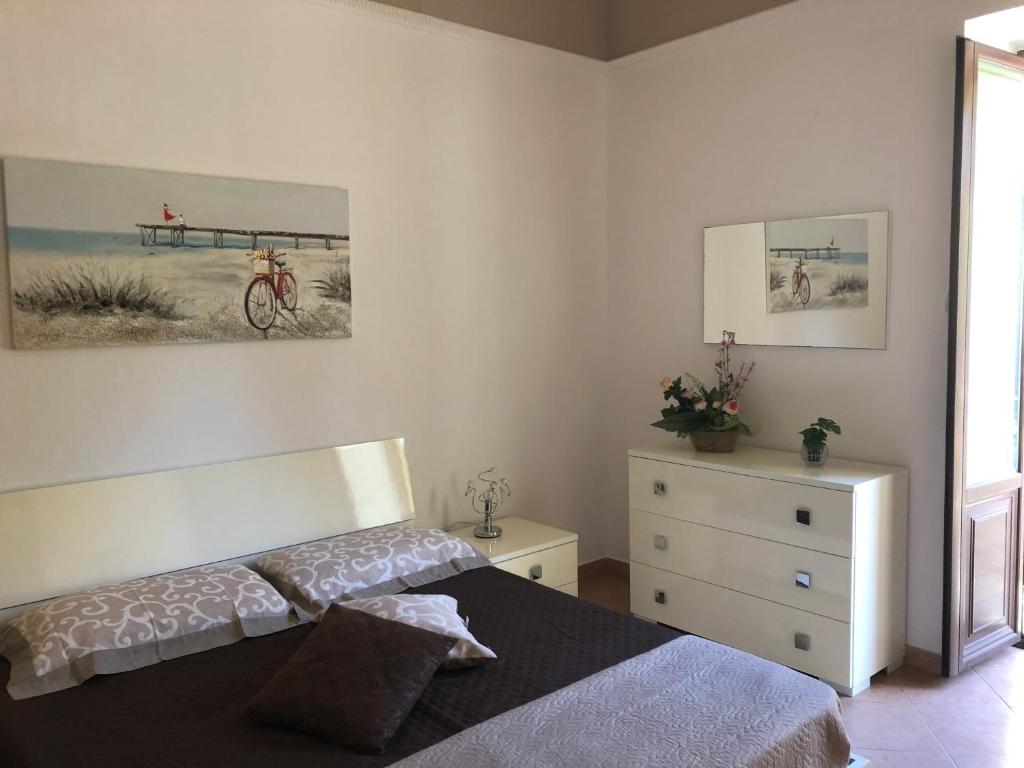 a bedroom with a bed and a dresser at La Casa Sulla Scogliera in Cefalù