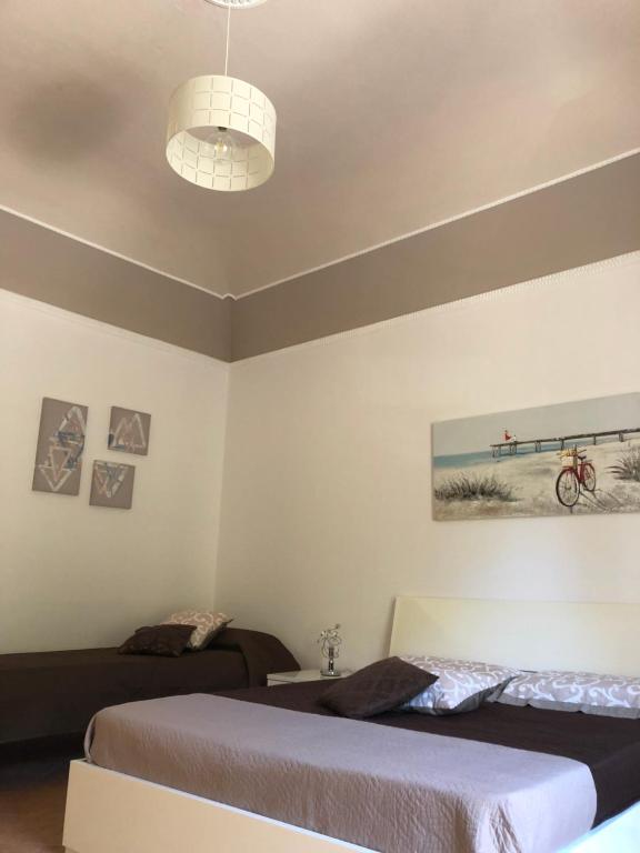 a bedroom with two beds and a ceiling at La Casa Sulla Scogliera in Cefalù