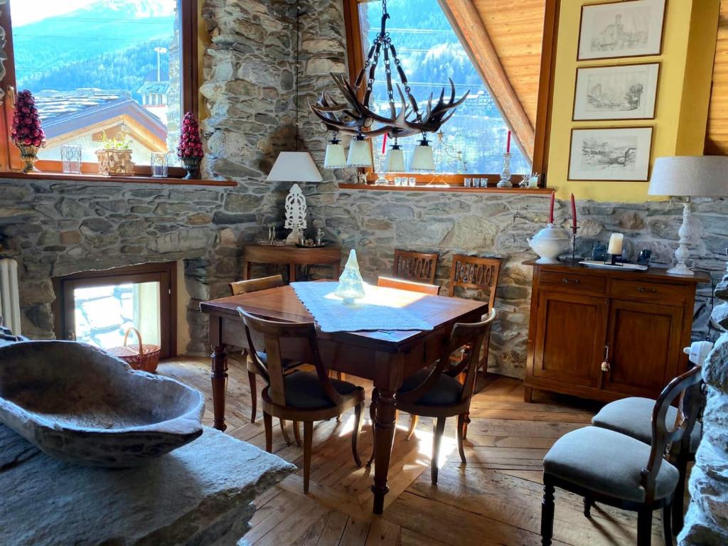 a dining room with a table and a stone wall at Maison Fort Bovet #Bluchalet in La Salle