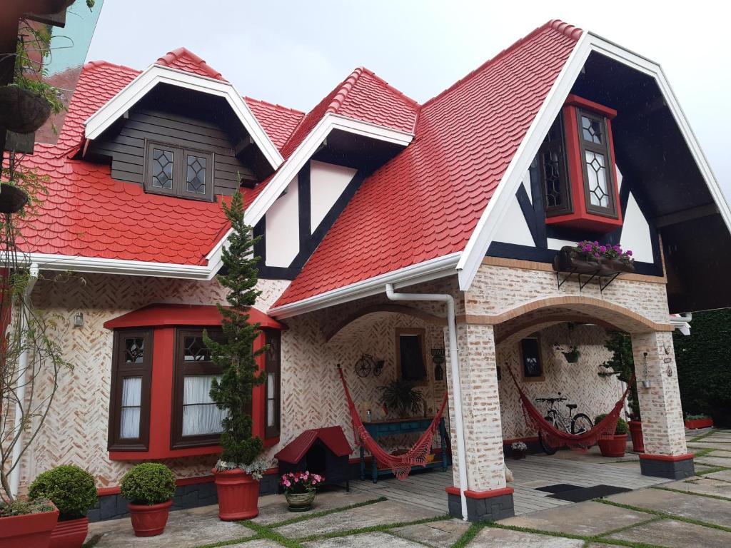 una casa con techo rojo en Pousada Toca dos Tucanos en Campos do Jordão