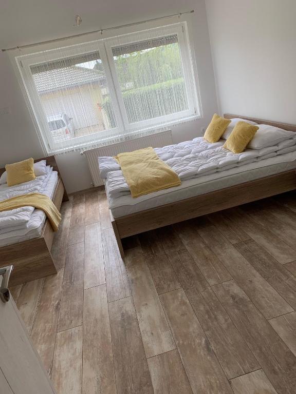 a bedroom with two beds and two windows at BB Vendégház in Villány