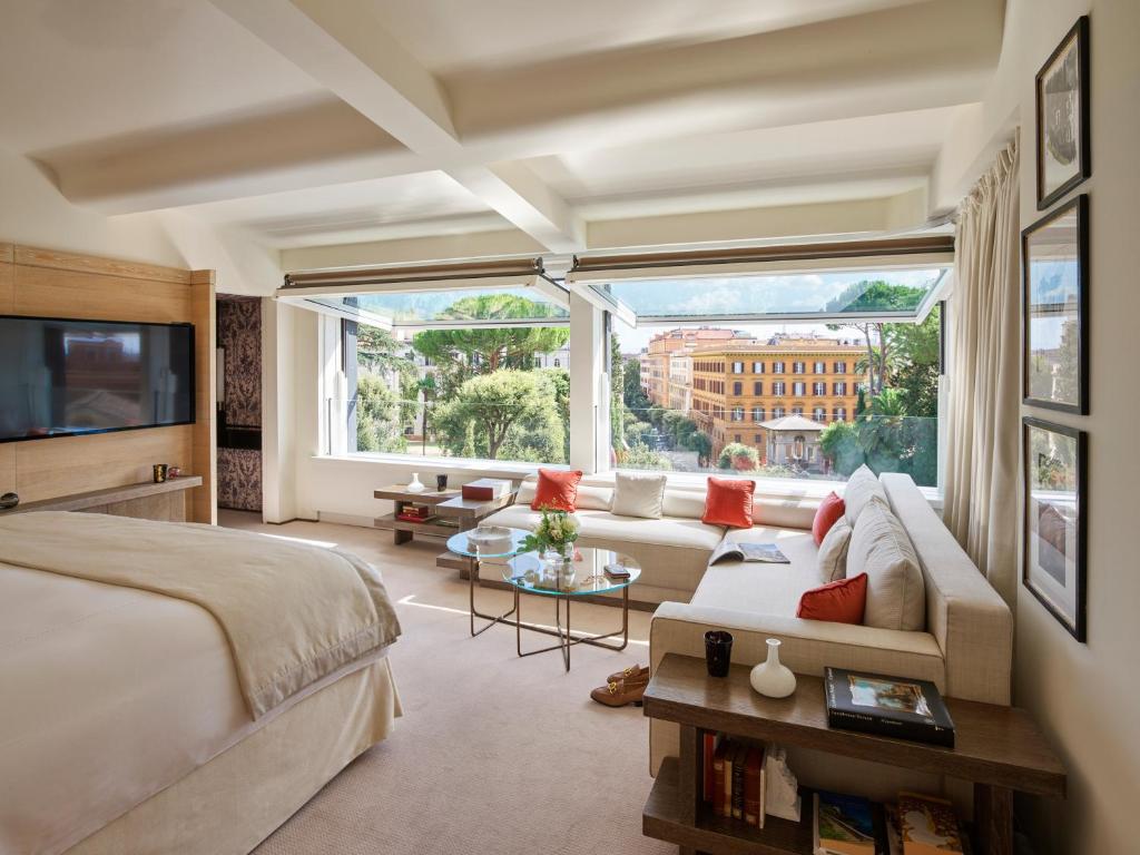 a hotel room with a bed and a large window at Hotel Eden - Dorchester Collection in Rome