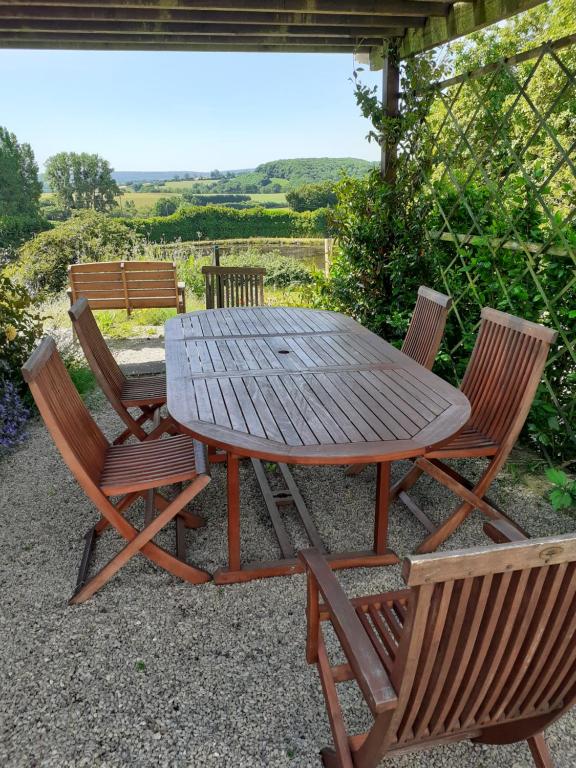 een houten tafel en twee stoelen naast een tafel bij Private farmhouse for six in the countryside in Saint-Pierre-sur-Orthe