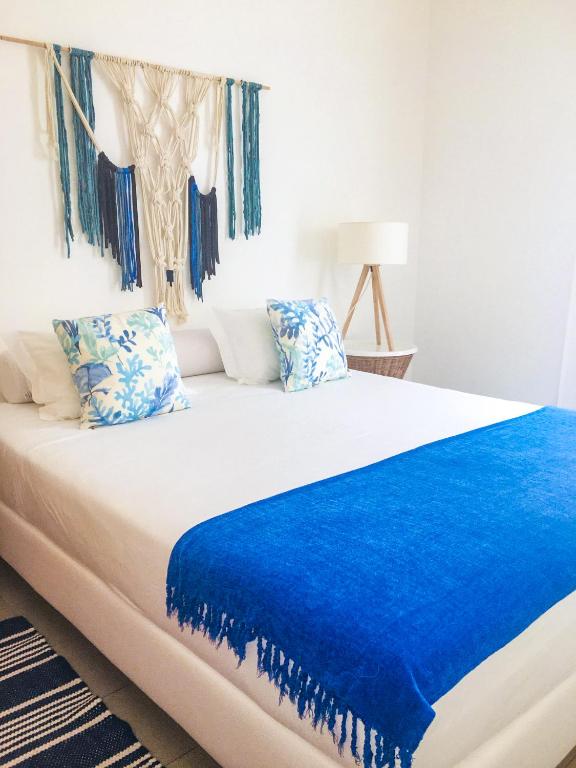 a bedroom with a bed with a blue blanket on it at Marina Club Lagos Resort in Lagos