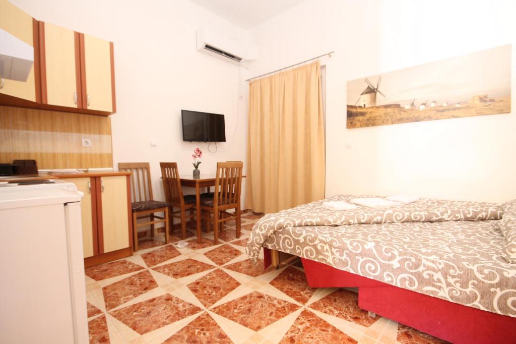 a bedroom with a bed and a kitchen and a table at Apartment with pool Tomic Boka Bay in Herceg-Novi