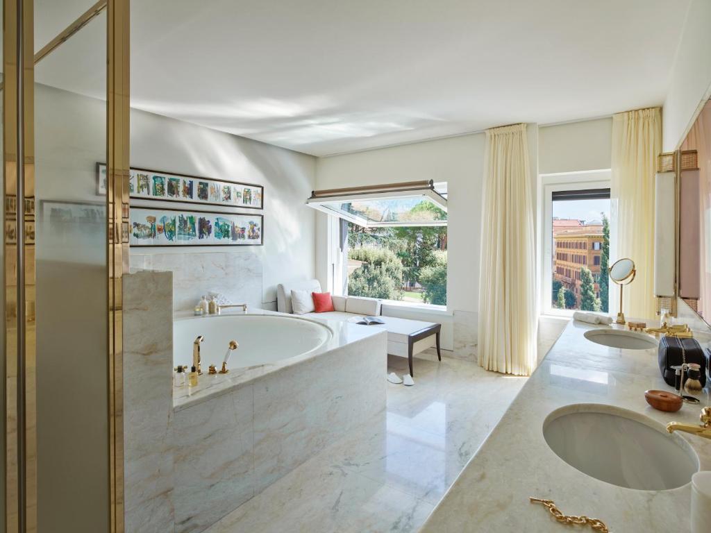 a large bathroom with two sinks and a tub at Hotel Eden - Dorchester Collection in Rome