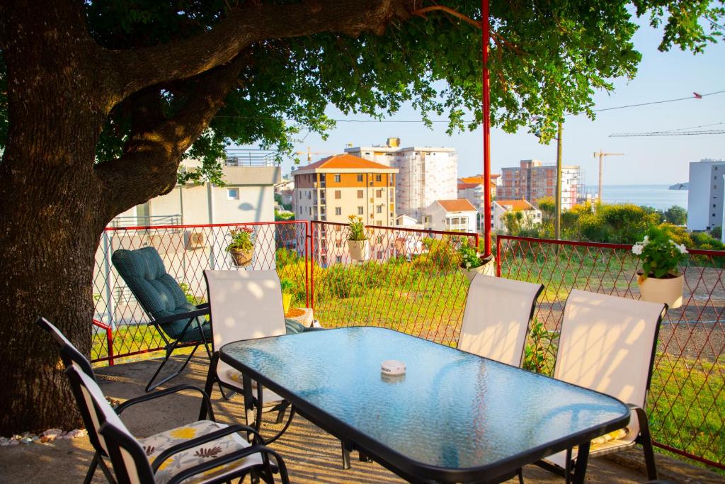 a table and chairs on a deck with a tree at 4 Studios Becic in Budva