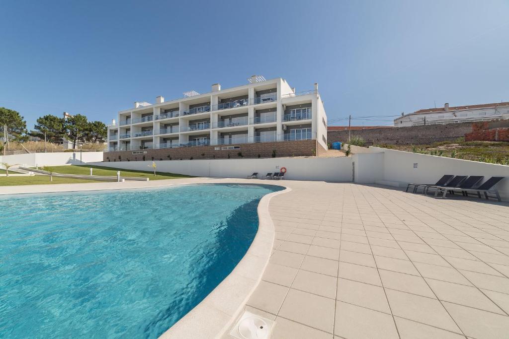 a swimming pool in front of a building at Muralha 2 - Holiday Apartments - By SCH in Nazaré