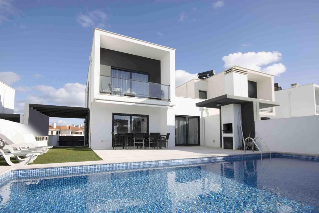 a white house with a swimming pool in front of it at Deluxe Villa - By SCH in Salir do Porto
