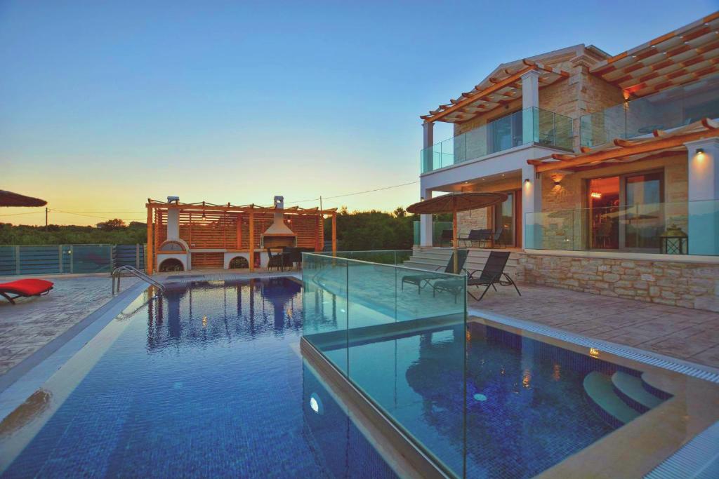 uma casa com piscina em frente a uma casa em Villa Zeas em Halikounas