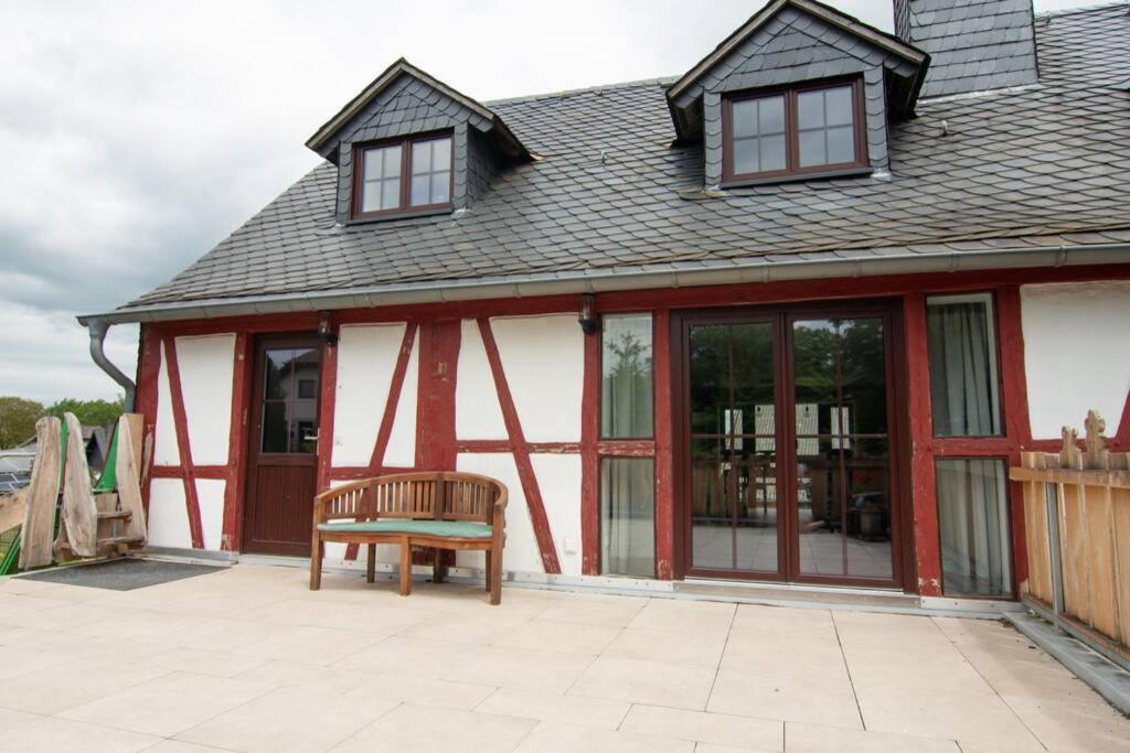 una casa con puertas de cristal y un banco en un patio en Ferienwohnung Träwa en Sulzbach