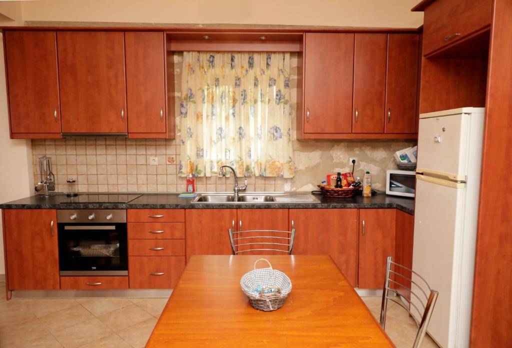 a kitchen with wooden cabinets and a wooden table at Zante Xigia Bay villas in Khartáta