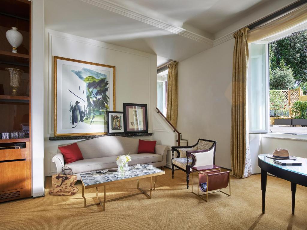 a living room with a couch and a table at Hotel Eden - Dorchester Collection in Rome