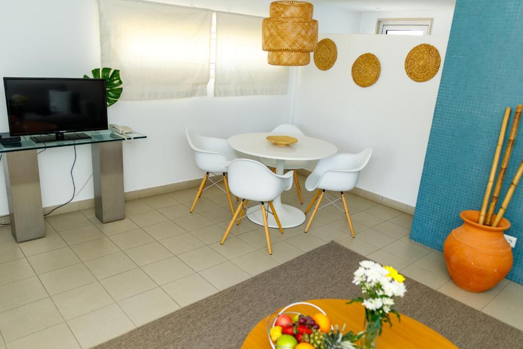 a living room with a table and white chairs at Marina Club Lagos Resort in Lagos