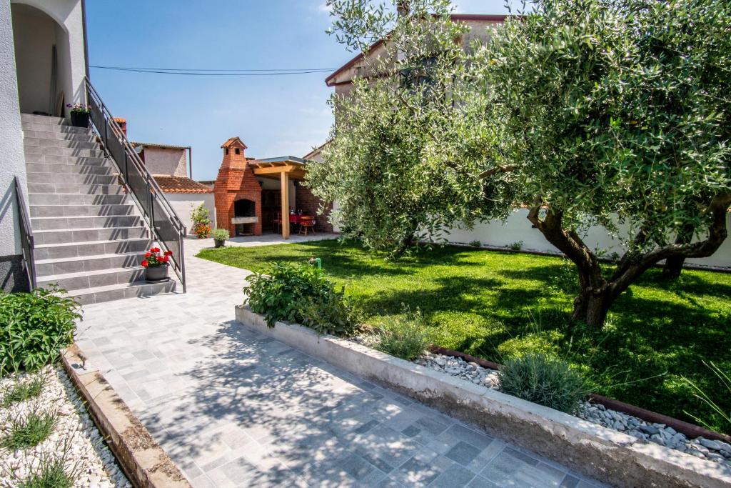 dom z drzewem i schodami na podwórku w obiekcie House Nada apartman w mieście Muntić