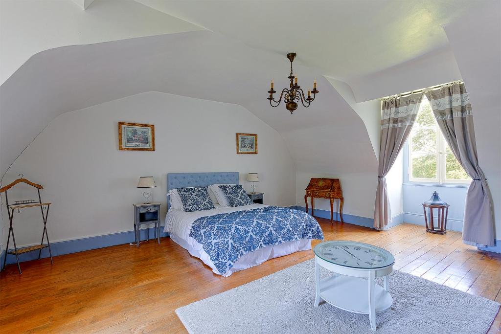 ein Schlafzimmer mit einem Bett und einem Tisch darin in der Unterkunft Manoir de la Mazeraie, idéal pour le télétravail in Joue-les-Tours