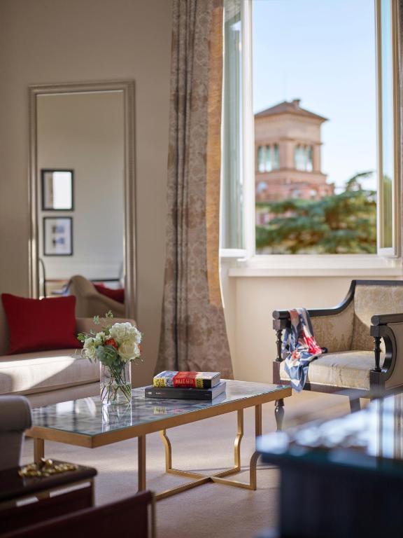 a living room with a couch and a table at Hotel Eden - Dorchester Collection in Rome