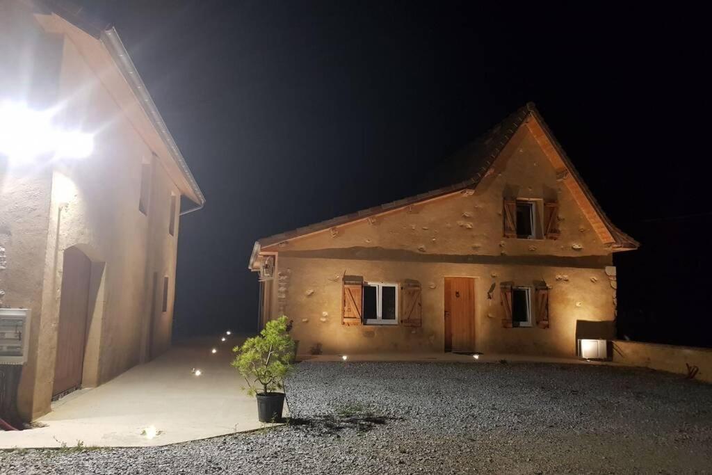 une maison la nuit avec une usine devant elle dans l'établissement Corps de Ferme Labarthe à Pimbo, à Pimbo