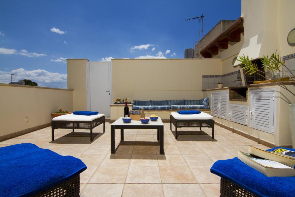 a patio with three chairs and tables on a roof at Gran Apartamento en Puerto in Port de Pollensa