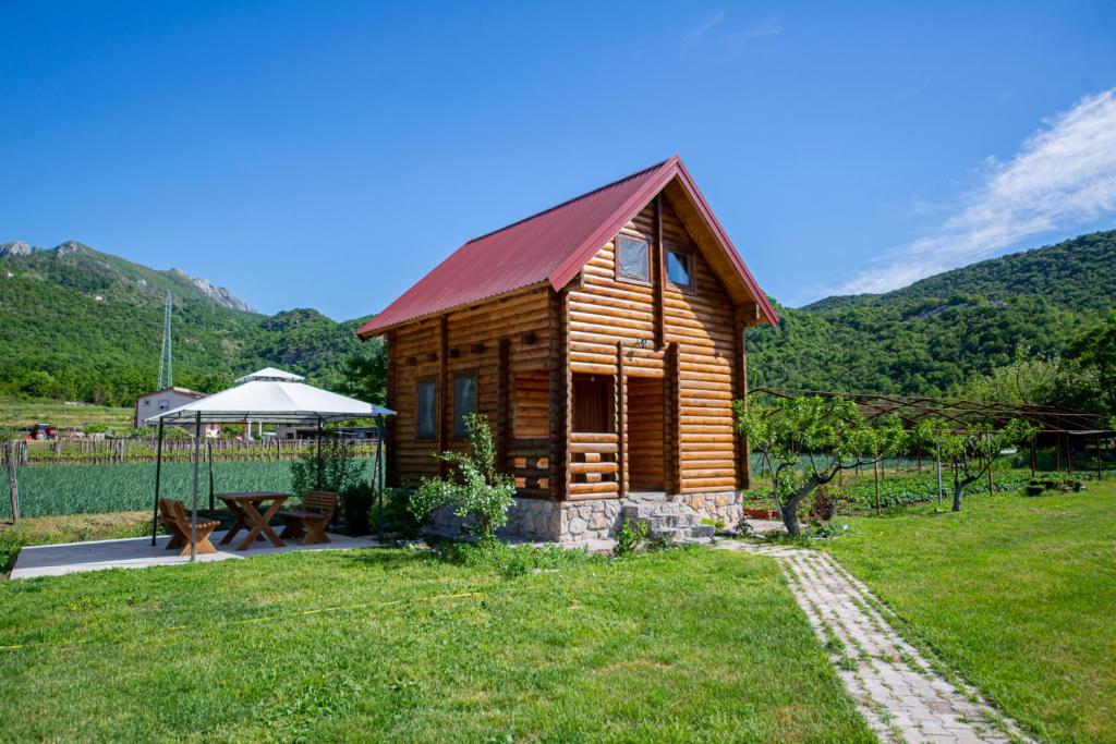 eine Blockhütte mit einem Picknicktisch und einem Pavillon in der Unterkunft Wood House in Virpazar