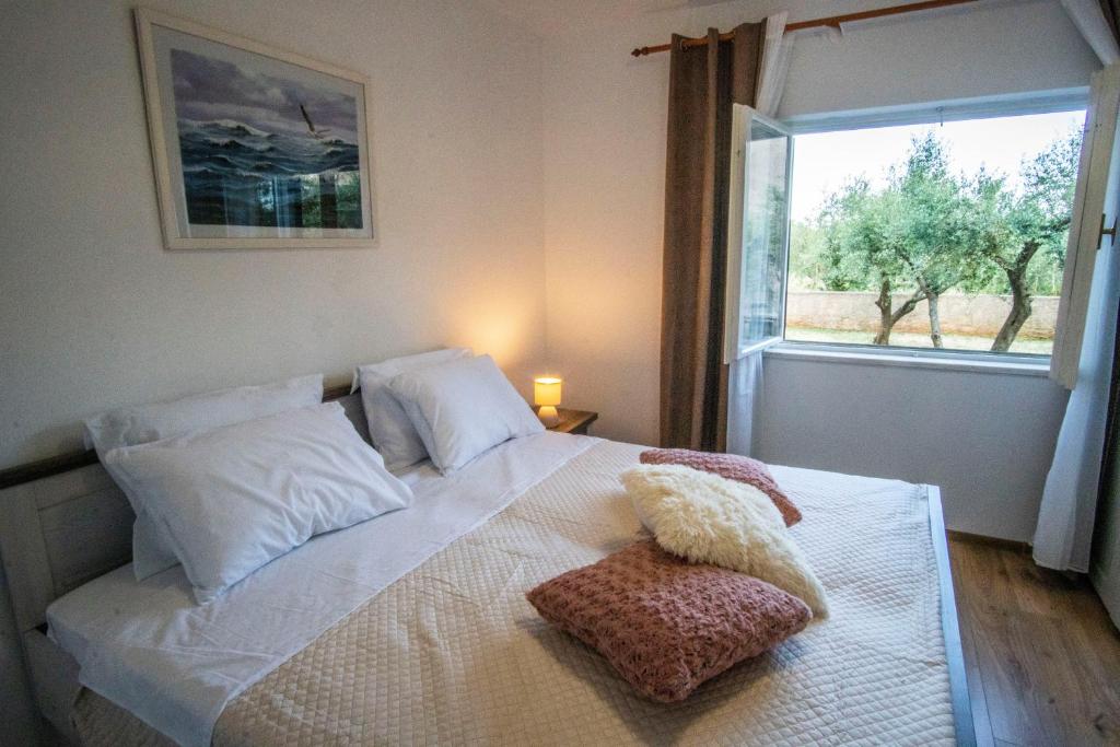 sypialnia z białym łóżkiem i oknem w obiekcie House Nada apartman w mieście Muntić