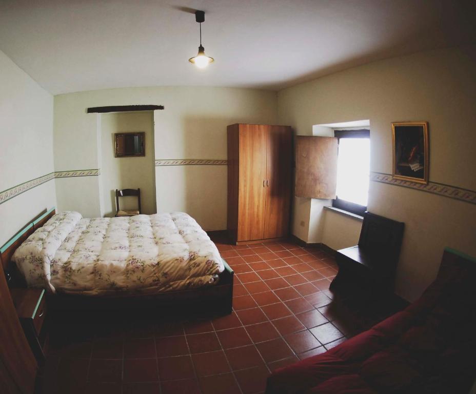 a bedroom with a bed and a couch in it at La Locanda del Convento in Rocca Sinibalda