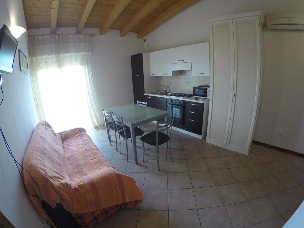 eine Küche und ein Esszimmer mit einem Tisch und Stühlen in der Unterkunft Residence Caorle Apartments - Agenzia Cocal in Caorle