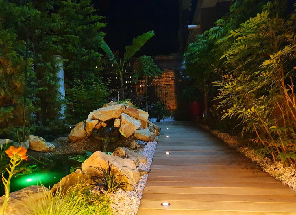a walkway in a garden at night with rocks at Nairi Apartment in Mamaia Nord