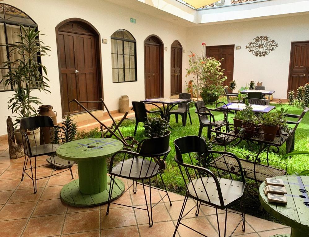 a patio with tables and chairs in a courtyard at Hostal Las Puertas in Santa Ana