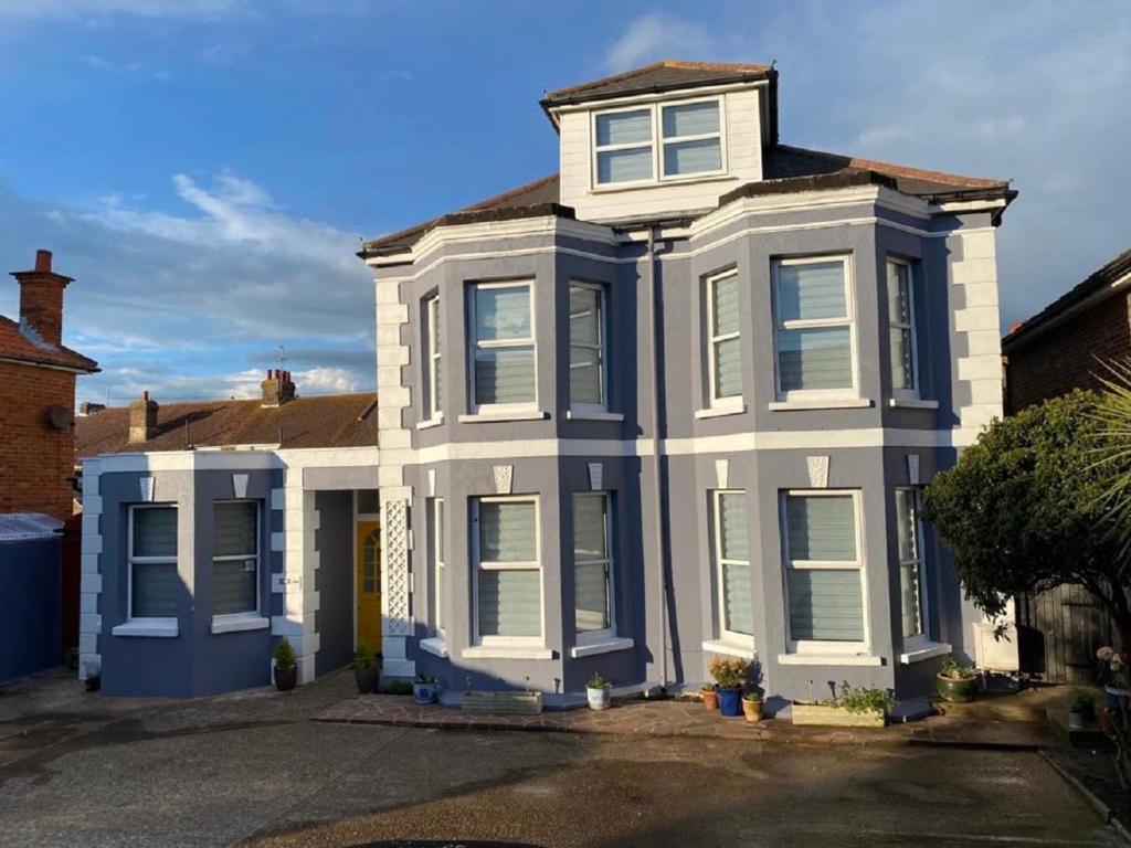 a blue and white house with white windows at Penhale Holiday Flats in Eastbourne