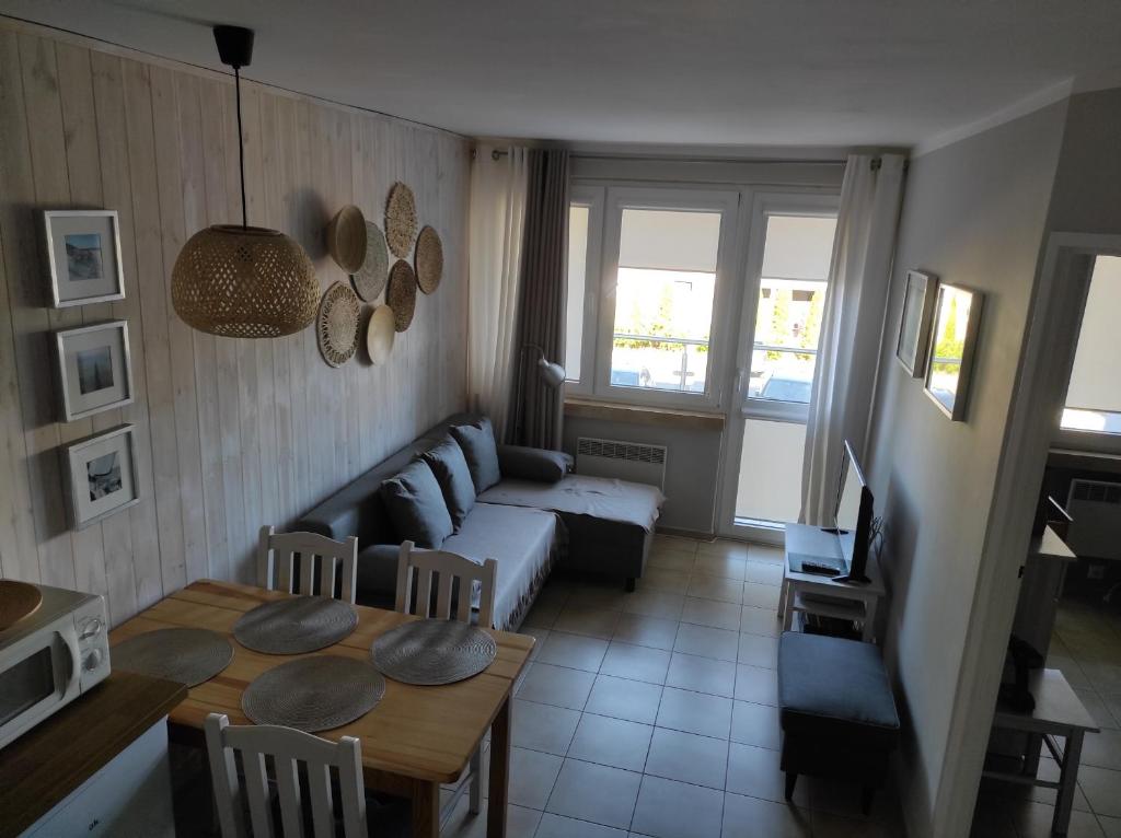ein Wohnzimmer mit einem Sofa und einem Tisch in der Unterkunft Dom Rybaka apartament 4 in Ustka