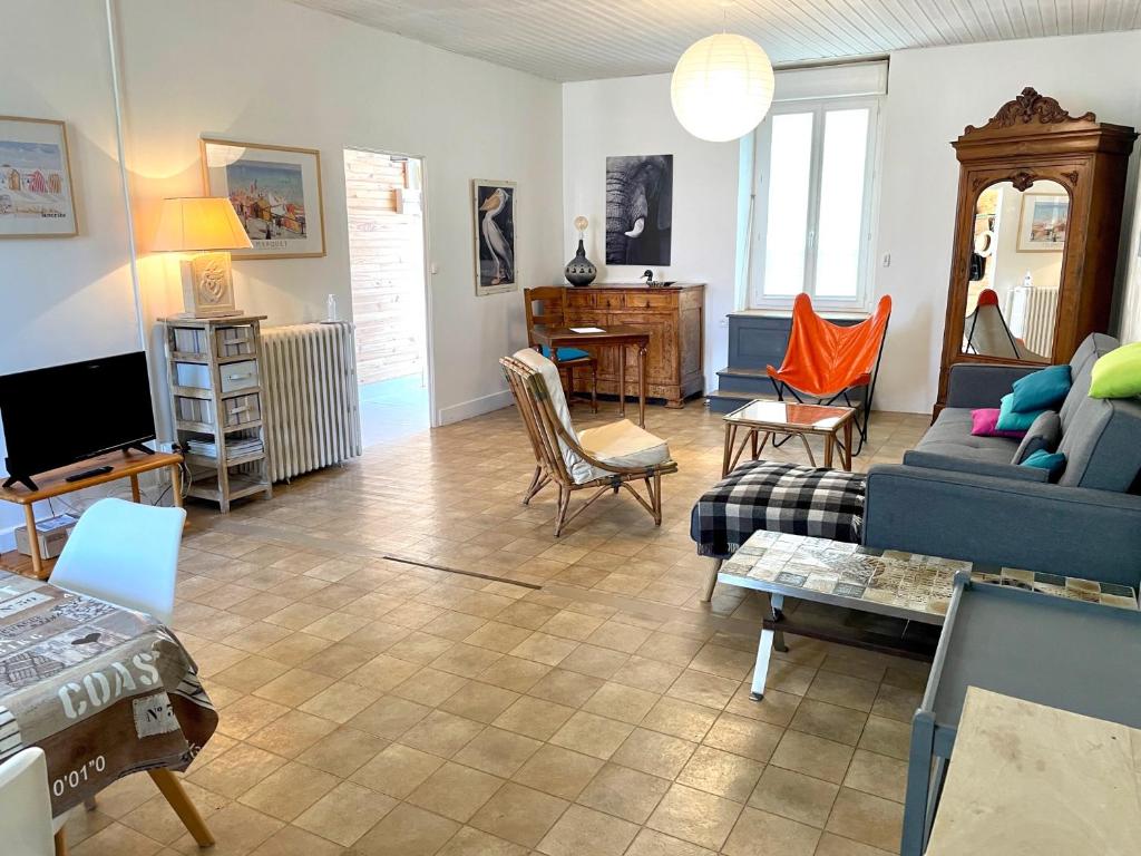 salon z niebieską kanapą i krzesłami w obiekcie Maison de famille aux Sables d'Olonne w mieście Les Sables-dʼOlonne