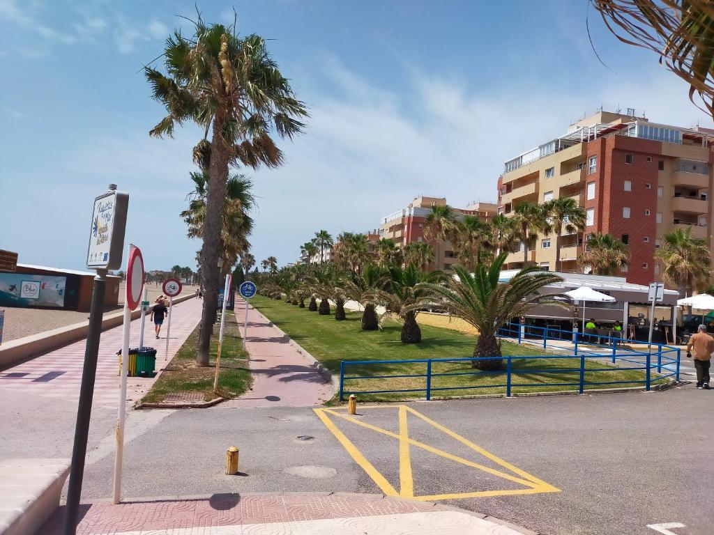a street with palm trees on the side of a road at Apartamento la romanilla a 200metros de la playa in Roquetas de Mar