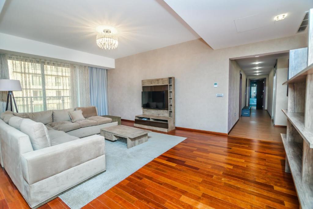 a living room with a couch and a tv at Megafun Residance B1 in Baku
