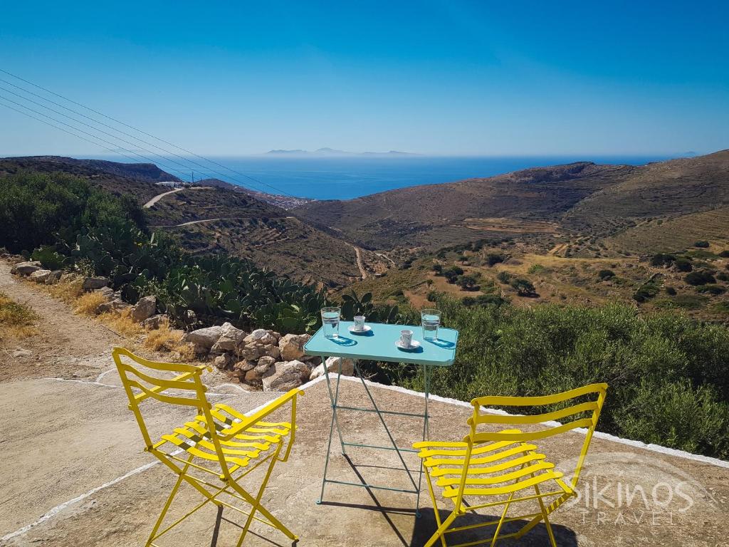two chairs and a table with a view of the ocean at Kastro Elegant House in Sikinos