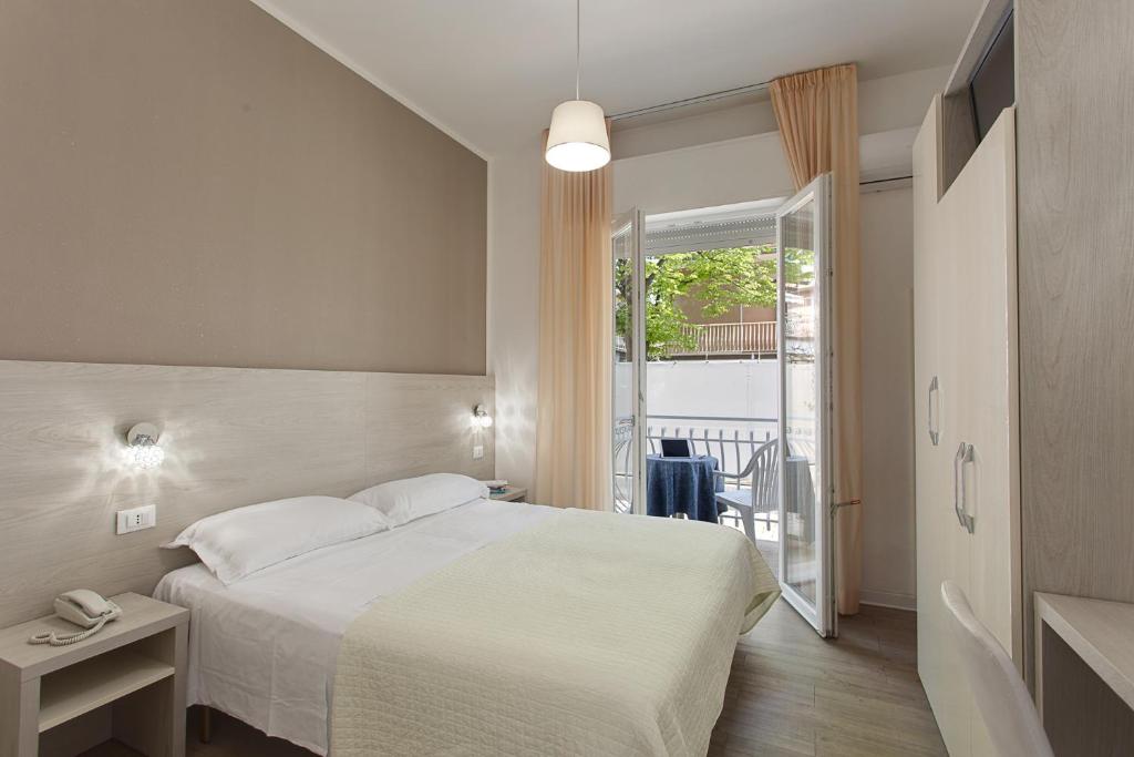 a hotel room with a bed and a balcony at Anastasi Residence in Cervia
