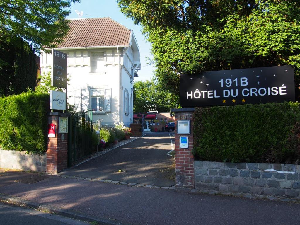 um sinal para um hotel du quoin em frente a uma casa em Hotel Du Croisé em Marcq-en-Baroeul