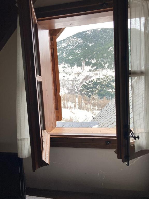 a window with a view of a snow covered mountain at Casa Planominguero in Taüll