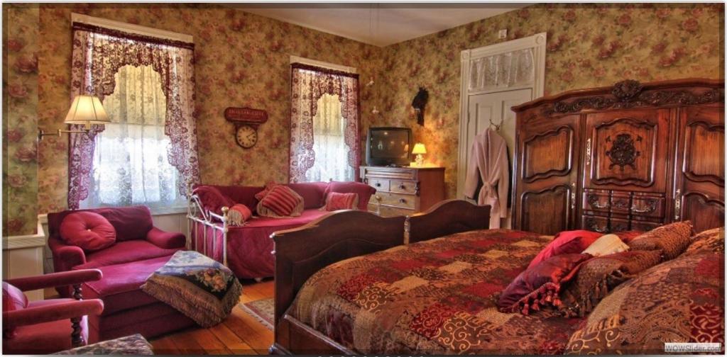 a bedroom with a bed and a couch and a chair at American River Inn in Georgetown