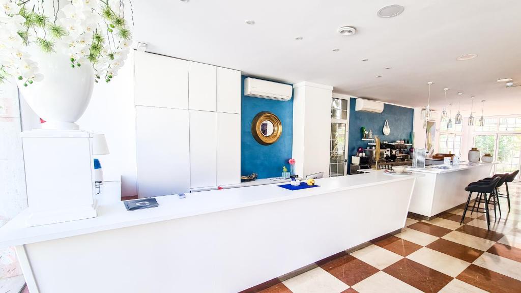 a kitchen with a white counter and a blue wall at Hotel Calafell Platja Mar in Calafell