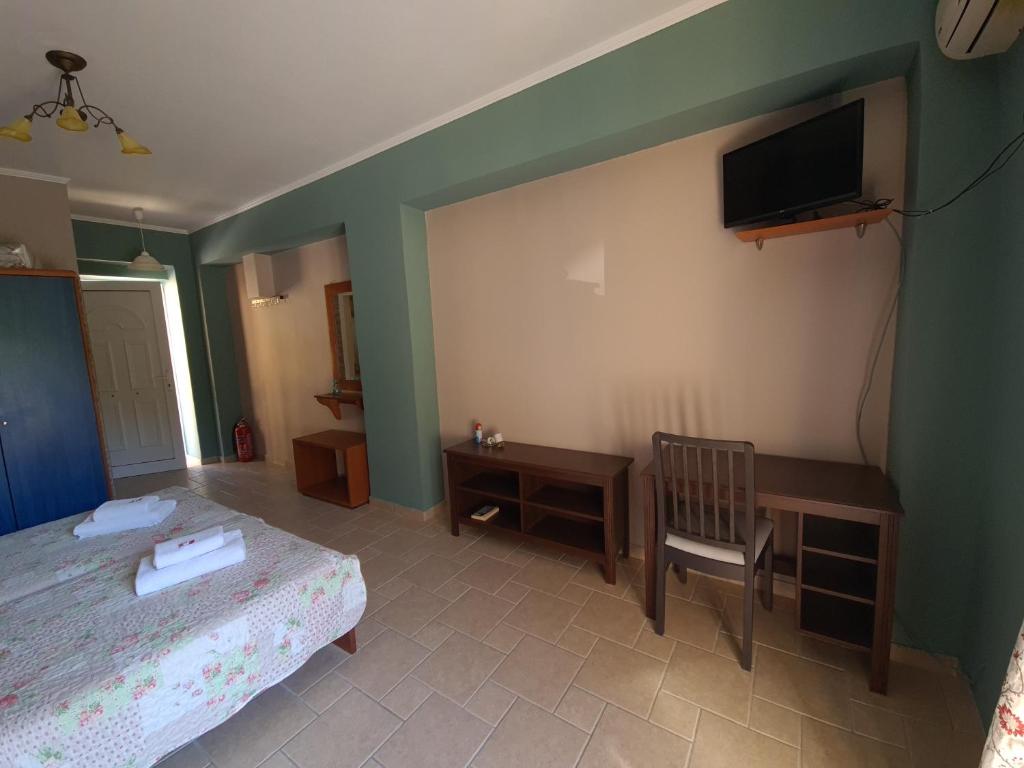 a bedroom with two beds and a desk and a television at Edem Studios in Syvota