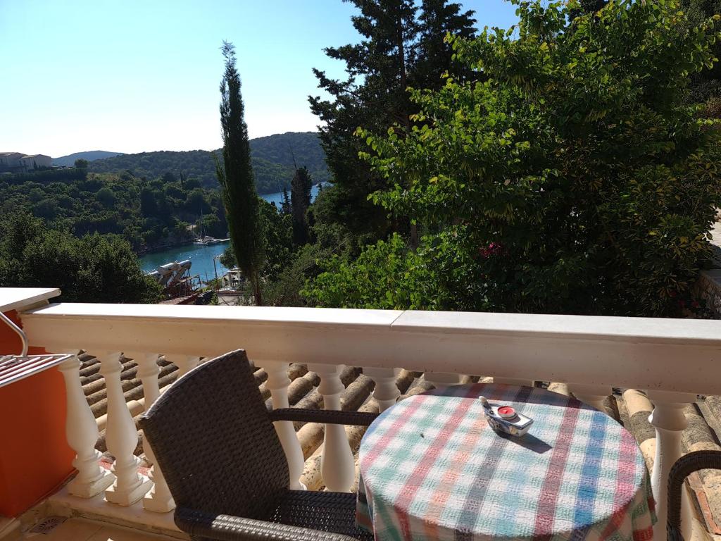 a table and chair on a balcony with a view at Edem Studios in Syvota