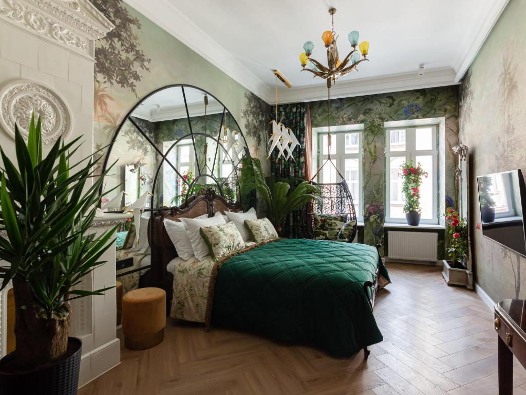 sypialnia z łóżkiem z zielonym kocem w obiekcie Mola Mola Apart Hotel w Lwowie