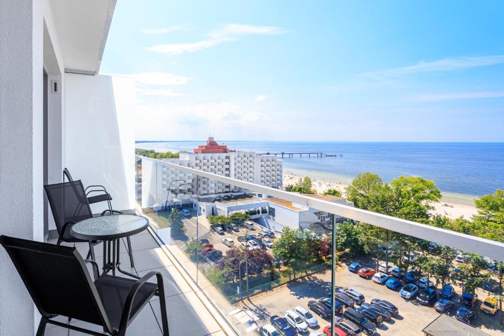 a balcony with chairs and a view of the ocean at Balticus Apartamenty Promenada Gwiazd 14 in Międzyzdroje