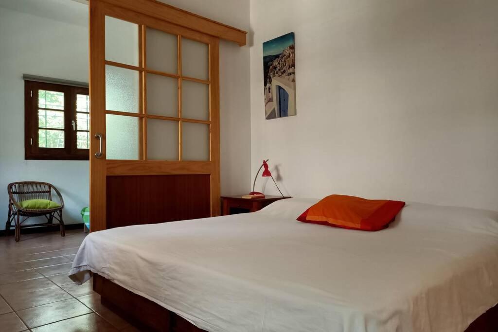 Un dormitorio con una gran cama blanca y una ventana en Apartamento-Bungalow con jardín y garaje, en Santa Cruz de Tenerife
