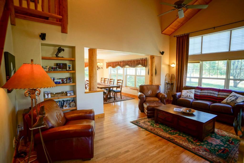 a living room with leather furniture and a table at Bear Creek Lodge Townhome in Steamboat Springs