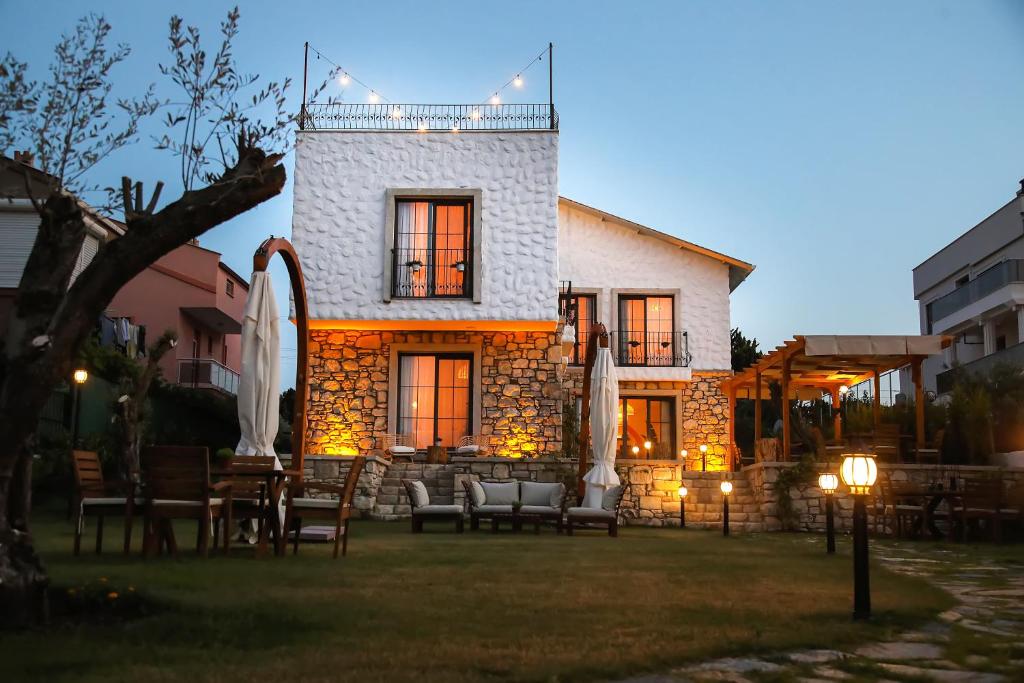 a building with chairs and tables in a yard at Huzurla otel in Izmir