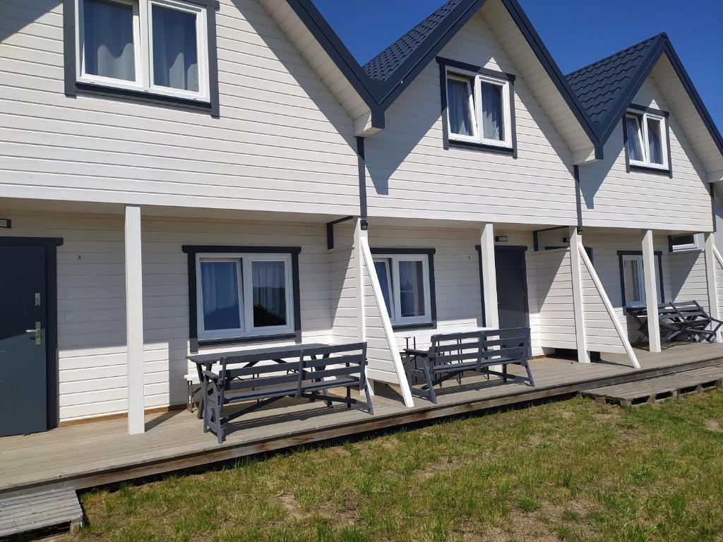 une maison avec bancs sur la terrasse couverte dans l'établissement Domki Noce i dnie, à Władysławowo