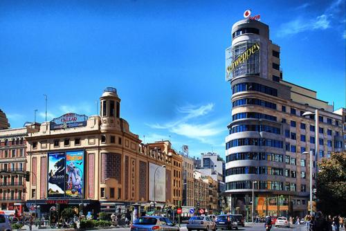 una concurrida calle de la ciudad con muchos edificios y coches en Sleeping Gran Via, en Madrid